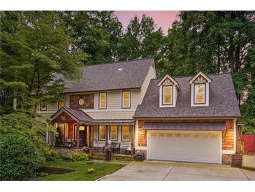 Charming two-story home with a covered porch, attached two-car garage, and lush landscaping at 1438 Salem Dr, Alpharetta, GA 30009