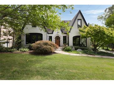 Charming home featuring a manicured lawn, mature trees, and a stone pathway leading to the front door at 1656 N Pelham Ne Rd, Atlanta, GA 30324