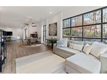 Bright living room with a large sectional sofa, natural light from expansive windows, and stylish decor at 1494 Red Fox Ne Dr # D, Atlanta, GA 30306