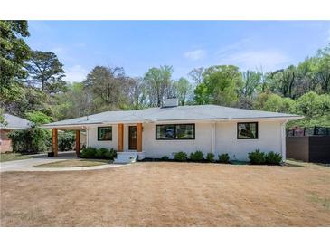 Charming single-story home with a white brick exterior, covered parking, and a well-maintained front yard at 4237 Rickenbacker Ne Way, Atlanta, GA 30342
