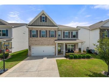 Charming two-story home featuring a brick facade, covered porch, and well-manicured lawn at 1570 Ribbon Mill Sw Ln, Mableton, GA 30126