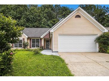Charming, single-story home with a two-car garage, tidy lawn, and mature trees at 1055 Avalon Dr, Lawrenceville, GA 30044