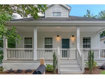 Charming home with a welcoming white front porch, columns, and a freshly landscaped yard at 1555 New Ne St, Atlanta, GA 30307