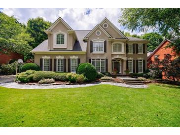 Elegant two-story home featuring a manicured lawn and a stone walkway leading to the front entrance at 4310 Granby Way, Marietta, GA 30062