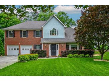 Charming two-story brick home with a well-manicured lawn and a two car garage at 10980 Pinehigh Dr, Alpharetta, GA 30022