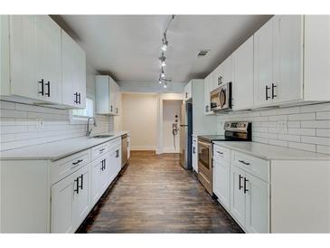 Bright kitchen features white cabinets, stainless steel appliances, and subway tile backsplash at 1914 North Nw Ave, Atlanta, GA 30318