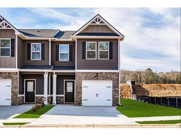 Charming townhome with brick and siding exterior, featuring an attached one-car garage and well-manicured lawn at 253 Ivey Ter # 48, Temple, GA 30179