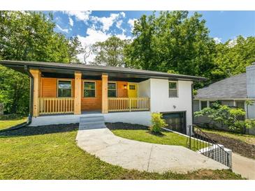 Charming home featuring a blend of wood and painted siding, covered porch, and a bright yellow front door at 1400 North Avenue Nw, Atlanta, GA 30318