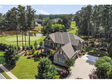 Stunning two-story brick home featuring a golf course view, lush landscaping, and a spacious driveway at 2380 Tayside Nw Xing, Kennesaw, GA 30152