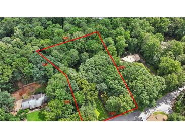An aerial view depicts the property lines encompassing a verdant, tree-filled landscape at 980 Hightower Trl, Sandy Springs, GA 30350