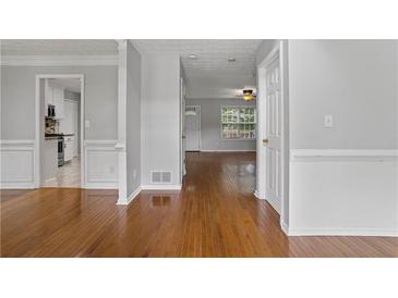 Cozy living room featuring hardwood floors and neutral color palette with views of the kitchen at 1048 Falls Brooke Dr, Conyers, GA 30094