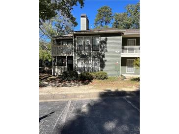 A two-story condo with green siding, multiple windows, and a small balcony is featured at 2697 Vinings Central Dr # 61, Atlanta, GA 30339