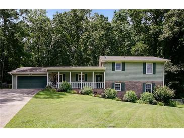 Charming two-story home with a spacious front yard and inviting front porch surrounded by lush trees at 3359 Villa Ln, Douglasville, GA 30135