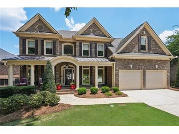 Charming two-story brick home featuring a front porch and manicured landscaping at 5511 Highland Preserve Dr, Mableton, GA 30126