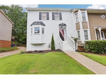 Charming townhome featuring a well-manicured lawn and a classic white-painted brick facade with black shutters at 208 Hembree Park Ter, Roswell, GA 30076