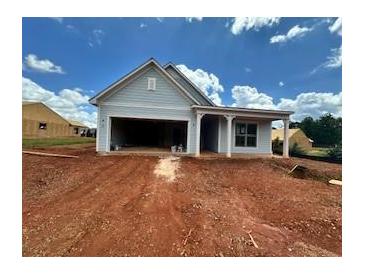 Charming single-story home featuring light blue siding, an attached garage, and inviting covered porch at 2407 Naples St, Hoschton, GA 30548