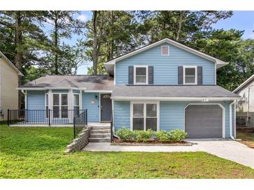 Charming two-story home with light blue siding, gray shutters, attached garage, and well-maintained front lawn at 6176 Hyde Park Ln, Lithonia, GA 30058