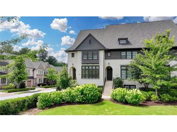 Beautiful exterior of this new construction, white painted brick townhouse with black trim and well landscaped lawn at 6399 Lucent Ln, Atlanta, GA 30328