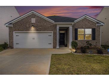 Charming brick home featuring a well-manicured lawn and a two-car garage for convenient parking at 2304 Pelham Pass, Dacula, GA 30019