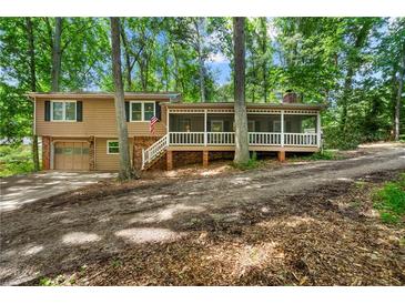 Inviting two-story home featuring a cozy screened porch, attached garage, and surrounded by lush trees at 4323 Japonica Sw Ct, Lilburn, GA 30047