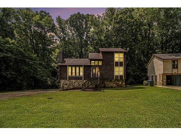 Charming two-story home with a stone foundation and lush greenery at 300 Twin Tendrils Sw, Atlanta, GA 30331