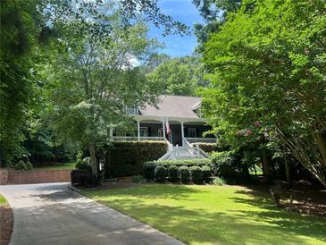 Charming home with a lush landscaped front yard, inviting porch and brick paved driveway at 507 Wintergreen Way, Canton, GA 30115