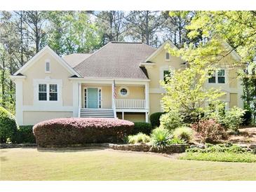 Charming home with a well-manicured front lawn and a welcoming entrance with a light blue front door at 1315 Pembridge Nw Way, Kennesaw, GA 30152