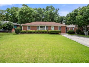 Charming brick home with a well-manicured lawn and mature landscaping at 135 5Th Ave, Jonesboro, GA 30236
