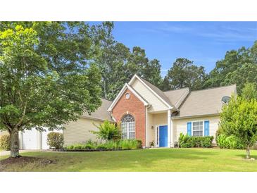 Charming single-Gathering home with a well-manicured lawn, blue door, and a mix of brick and vinyl siding at 1530 Brisbane Dr, Dacula, GA 30019