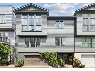 Contemporary townhome with gray siding, large windows, and a two-car garage with verdant foliage at , Atlanta, GA 30315