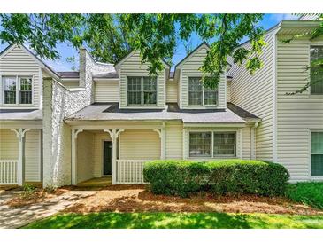 Charming townhome with a welcoming front porch, lush landscaping, and classic architectural details at 1003 Cannongate Sw Xing, Marietta, GA 30064
