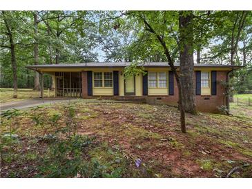 Charming single-story brick home with a well-maintained front yard surrounded by mature trees at 223 Dogwood Ln, Lawrenceville, GA 30046