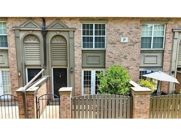 Charming brick townhouse with a small fenced-in patio and covered front entryways at 6980 Roswell Rd # P6, Atlanta, GA 30328