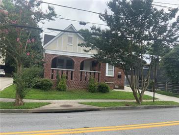 Charming brick home with a manicured lawn and quaint architectural details at 563 Ralph Mcgill Ne Blvd, Atlanta, GA 30312