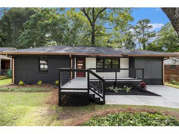 Charming renovated home with modern exterior, featuring a painted brick facade, new porch and stylish black and white accents at 1853 Pinedale Pl, Decatur, GA 30032
