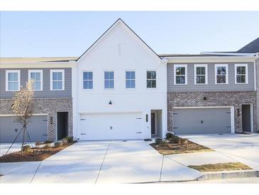 Charming townhouse showcases a modern exterior design with a two-car garage and well-manicured landscaping at 907 Agate Ln, Lawrenceville, GA 30043