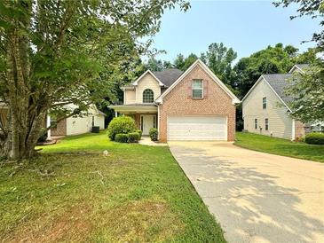 Charming two-story brick home with well-manicured lawn and a long driveway, perfect for Gathering living at 105 Avonwood Cir, Locust Grove, GA 30248