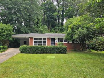 Charming brick home featuring a well-manicured front lawn and mature trees, providing a peaceful setting at 813 Crockett Ct, Decatur, GA 30033