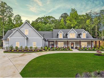 Beautifully landscaped home with a rocking chair front porch and lush green lawn at 540 Byrd Mountain Ln, Canton, GA 30114