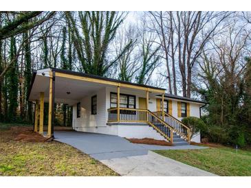 Charming home featuring a carport and landscaped front yard on a sunny day at 2895 Akron St, Atlanta, GA 30344