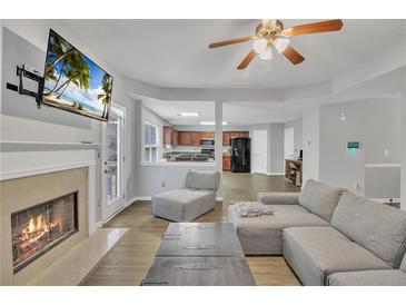 Open-concept living room featuring fireplace, modern furniture, and seamless flow to the kitchen at 4240 N Braves Cir, Douglasville, GA 30135