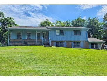 Charming blue two-story home featuring a brick foundation and a spacious front yard at 2175 Surrey Trl, Atlanta, GA 30349