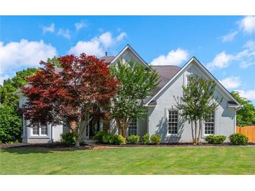 Beautiful exterior featuring a well-manicured lawn, grey siding and mature trees at 2000 Settindown Dr, Roswell, GA 30075
