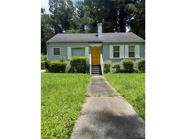 Charming single-story home with a yellow door, a well-manicured lawn and shrubbery at 247 Whitaker Nw Cir, Atlanta, GA 30314