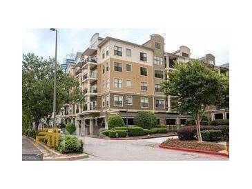 Beautiful multi-story condo building with tan facade, balconies, manicured landscaping, and street access at 799 Hammond Drive # 409, Sandy Springs, GA 30328