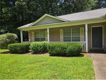 Charming one-story brick home with a covered porch and manicured landscaping at 101 Royal Way, Mcdonough, GA 30252