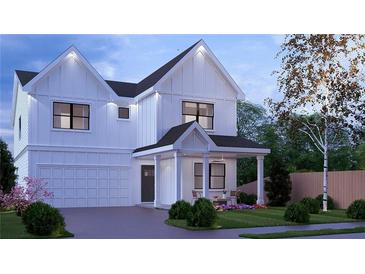 Charming two-story home with white siding, front porch, manicured lawn and attached two-car garage at 2606 Church Nw St, Atlanta, GA 30318