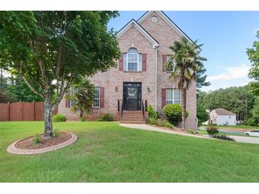 Charming brick home features a well-manicured lawn, mature trees, and inviting curb appeal at 3190 Red Rose Dr, Powder Springs, GA 30127