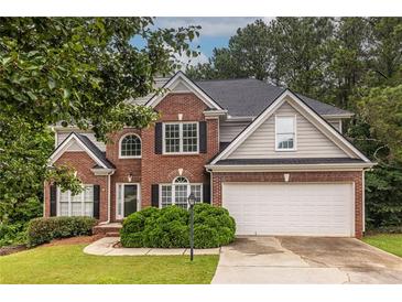 Charming two-story brick home featuring a well-maintained lawn and attached two car garage at 616 Piping Rock Pt, Lawrenceville, GA 30043