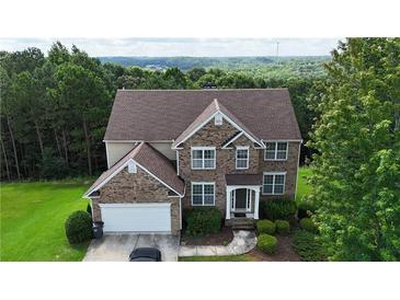 Beautiful two-story brick home with a well-manicured lawn and lush landscaping at 773 Van Briggle Path, Sugar Hill, GA 30518